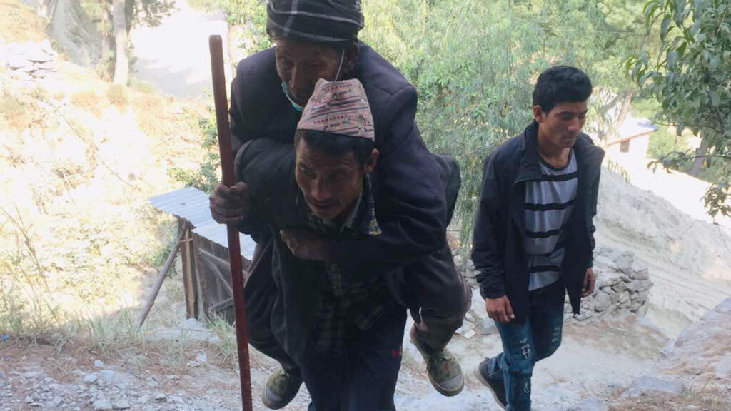 son carries father Blindness in Nepal